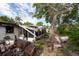 View of a severely damaged home exterior showcasing fire damage, debris, and overgrown yard at 4111 W Marietta St, Tampa, FL 33616