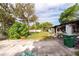 View of driveway leading to the house with an overgrown lawn and debris at 4111 W Marietta St, Tampa, FL 33616