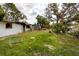 Exterior view showing overgrown front lawn and a damaged house at 4111 W Marietta St, Tampa, FL 33616