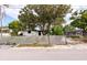 Street view of the distressed house and fenced front yard with mature trees at 4111 W Marietta St, Tampa, FL 33616