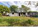 View of the house showing fire damage and debris scattered on the unkempt front lawn at 4111 W Marietta St, Tampa, FL 33616