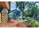 Landscaped backyard with lush greenery, a small pond, and a screened-in pool area at 4801 Lynn Oaks Cir, Dover, FL 33527