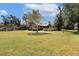 Lush green backyard view of a well-maintained log home surrounded by mature trees at 4801 Lynn Oaks Cir, Dover, FL 33527