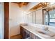 Bathroom featuring a double sink vanity with marble countertop, and exposed wood beam ceiling with a chandelier at 4801 Lynn Oaks Cir, Dover, FL 33527