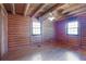 Log-walled bedroom with hardwood floors, ceiling fan, and natural light from two windows at 4801 Lynn Oaks Cir, Dover, FL 33527