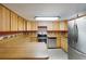 Well-lit kitchen boasts wood cabinets, modern appliances, laminate countertops, and decorative backsplash detail at 4801 Lynn Oaks Cir, Dover, FL 33527