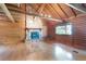 Open living room boasts a stone fireplace, wood walls, laminate flooring, and large windows at 4801 Lynn Oaks Cir, Dover, FL 33527