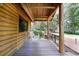 Rustic exterior porch featuring wood floors, wood railing, wood swing, and wood support beam at 4801 Lynn Oaks Cir, Dover, FL 33527