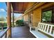 Charming porch with a wooden swing, log siding, and a cozy rustic appeal at 4801 Lynn Oaks Cir, Dover, FL 33527
