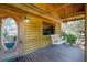 Inviting log cabin-style porch with a swing and an oval-window front door at 4801 Lynn Oaks Cir, Dover, FL 33527
