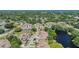 Expansive aerial view of neighborhood homes, surrounded by mature trees and a serene pond, emphasizing the community's charm at 486 Lakeview Dr # 54, Palm Harbor, FL 34683