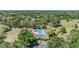 Aerial view of a community pool surrounded by beautiful green trees and a clubhouse at 486 Lakeview Dr # 54, Palm Harbor, FL 34683