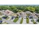 Aerial view of residences with pristine lawns and landscaping, surrounded by mature trees and a pond, highlighting the neighborhood at 486 Lakeview Dr # 54, Palm Harbor, FL 34683