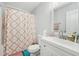 Cozy bathroom featuring a vanity, toilet, shower with patterned curtain, and plush floor mats at 5302 Aloha Seed Dr, Seffner, FL 33584