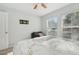 Bedroom featuring neutral walls, ceiling fan, two large windows, and a full-size bed with accent pillows at 5302 Aloha Seed Dr, Seffner, FL 33584