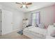 A small bedroom featuring a ceiling fan, bright window, and ample closet space at 5302 Aloha Seed Dr, Seffner, FL 33584