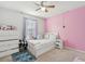A simple, neat bedroom with pink accents, a ceiling fan, and a bright window at 5302 Aloha Seed Dr, Seffner, FL 33584