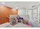 Neutral-toned room with carpet, play area, a splash of color from a single orange wall, and open doorways at 5302 Aloha Seed Dr, Seffner, FL 33584