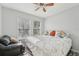 Bedroom featuring neutral walls, ceiling fan, two large windows, and a full-size bed with accent pillows at 5302 Aloha Seed Dr, Seffner, FL 33584