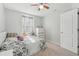 A simple bedroom with a floral-patterned bed, a ceiling fan, and a bright window at 5302 Aloha Seed Dr, Seffner, FL 33584