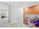 Neutral-toned room with carpet, play area, a splash of color from a single orange wall, and an open doorway at 5302 Aloha Seed Dr, Seffner, FL 33584