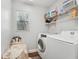 Convenient laundry room with a white washer, dryer, wire shelving, and natural light from a window at 5302 Aloha Seed Dr, Seffner, FL 33584
