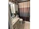 Neutral-toned bathroom featuring a vanity with storage, toilet, and shower with a stylish striped curtain at 6190 80Th N St # 204, St Petersburg, FL 33709