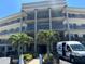Attractive condo building entrance with lush landscaping and mature palm trees on a sunny day at 6190 80Th N St # 204, St Petersburg, FL 33709