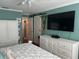Bright bedroom with hardwood floors, a TV, an open closet with barn door, and white dressers for ample storage at 6190 80Th N St # 204, St Petersburg, FL 33709