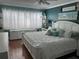 Main bedroom featuring a plush bed, hardwood flooring, a large window with shutter blinds, and tasteful decorations at 6190 80Th N St # 204, St Petersburg, FL 33709