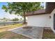 A concrete patio in a waterfront backyard with a large tree providing shade near the water and adjacent docks at 8721 Bay Crest Ln, Tampa, FL 33615