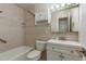 This bathroom features tiled walls, a shower and bath, toilet, and sink with vanity at 8721 Bay Crest Ln, Tampa, FL 33615