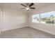 Bright bedroom with neutral walls, ceiling fan, and large window with a view of outdoors at 8721 Bay Crest Ln, Tampa, FL 33615