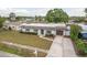 Charming single-story home featuring a well-manicured lawn, mature landscaping and a long driveway at 8721 Bay Crest Ln, Tampa, FL 33615