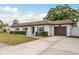 Charming single-story home with a well-manicured lawn, clean design, and a two-car garage at 8721 Bay Crest Ln, Tampa, FL 33615
