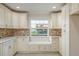 A kitchen with white cabinets and a window with bench seating and storage at 8721 Bay Crest Ln, Tampa, FL 33615