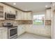 Kitchen with stainless steel appliances and large window with bench seating and storage at 8721 Bay Crest Ln, Tampa, FL 33615