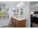 Bathroom vanity with double sinks, wood cabinets, large mirror, and lots of natural light at 9534 W Park Village Dr, Tampa, FL 33626
