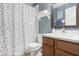 Bright bathroom with a vanity and sink, a toilet, and a shower with a colorful polka dot shower curtain at 9534 W Park Village Dr, Tampa, FL 33626