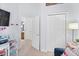 Comfortable room features a closet, view into bathroom, and a desk setup with printer and other materials at 9534 W Park Village Dr, Tampa, FL 33626