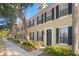 Charming townhouse featuring a well-manicured lawn, a black front door, and black shutters at 9534 W Park Village Dr, Tampa, FL 33626