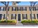 Charming townhouse featuring a well-manicured lawn, a black front door, and black shutters at 9534 W Park Village Dr, Tampa, FL 33626