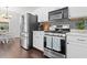 Modern kitchen with stainless steel appliances, white cabinets, and decorative backsplash at 9534 W Park Village Dr, Tampa, FL 33626
