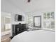 Spacious primary bedroom featuring large windows, dark wood furnishings, a tv and ensuite bathroom at 9534 W Park Village Dr, Tampa, FL 33626