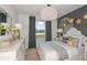 Serene bedroom with decorative lighting, gray accents, and a large window overlooking the outdoors at 9979 Trellis Vine Way, Parrish, FL 34219