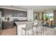 Open kitchen with island seating and modern appliances adjacent to the dining area at 9979 Trellis Vine Way, Parrish, FL 34219