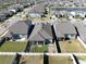 An aerial view of the backyard highlighting its fully fenced perimeter, garden plots, and screened in patio at 10303 Malvasia Ave, Riverview, FL 33578