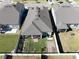 A high-angle view of the backyard, showcasing a fully fenced yard with garden plots and screened-in patio at 10303 Malvasia Ave, Riverview, FL 33578
