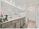 Bathroom featuring a double vanity with gray cabinets, stylish fixtures, and decorative pet-themed art at 10303 Malvasia Ave, Riverview, FL 33578
