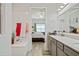 Bathroom featuring a double vanity and gray cabinets as well as a view of the bedroom at 10303 Malvasia Ave, Riverview, FL 33578